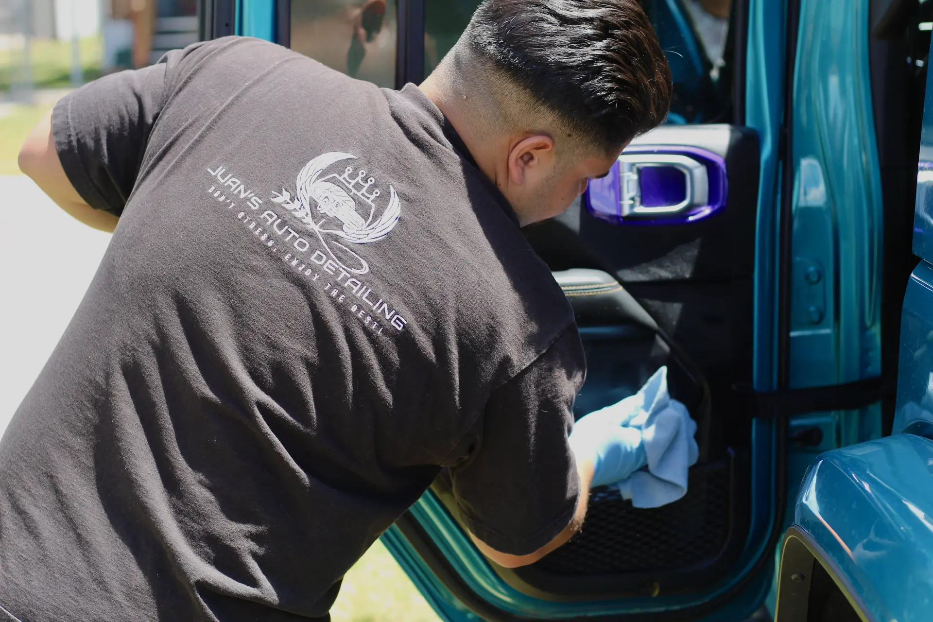 Technician detailing door jamb on teal Jeep — Box Elder County